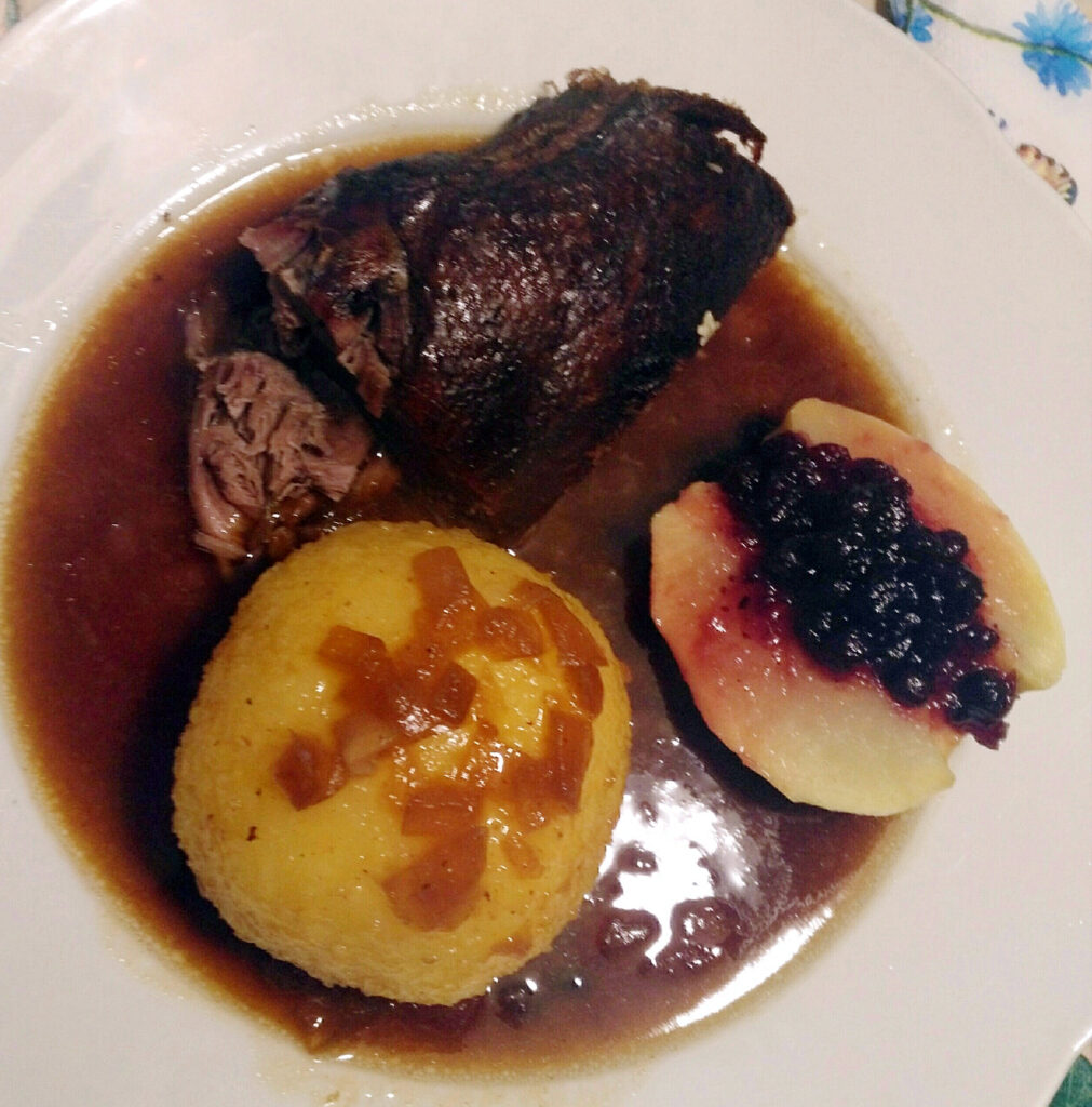 Gänsebrust mit Knödel und Soß und Preiselbeeren mit einem gedünsteten Apfel